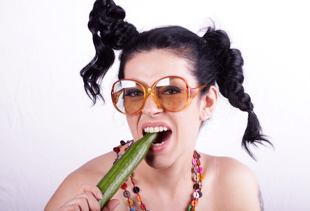 Feliz joven mujer comiendo pepino
 - Foto, imagen
