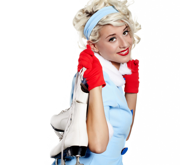 Smiling pinup woman carrying a pair of ice skates - Foto, immagini