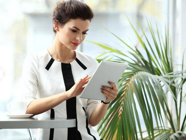 Pensive businesswoman reading an article on tablet computer - Photo, image