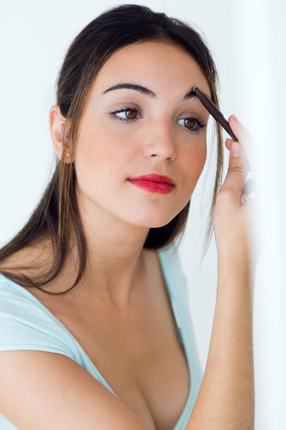 Beautiful young woman making make-up near mirror. - Zdjęcie, obraz