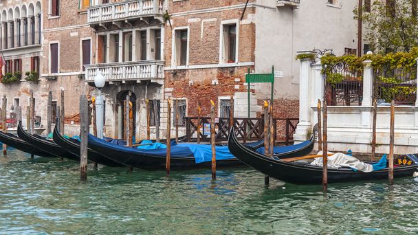 VENICE, ITALY - on APRIL 30, 2015. An architectural complex of ancient buildings on the bank of the Grand channel (Canal Grande). Gondolas at pier. The grand channel is the main transport artery of Venice and its most known channel - Photo, Image