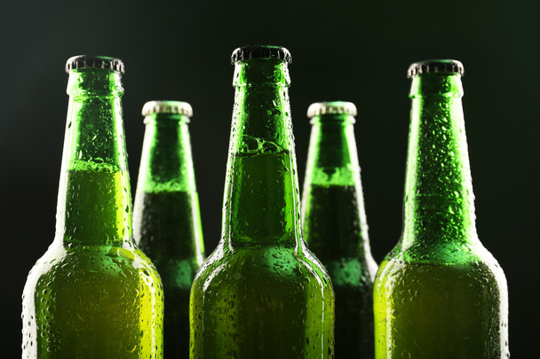 Glass bottles of beer on dark background - Фото, изображение