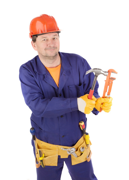 Worker in protective helmet holding hammers. - 写真・画像