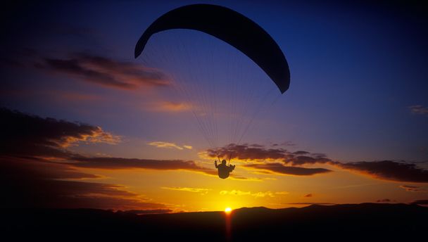 Paraglider bij zonsondergang. - Foto, afbeelding