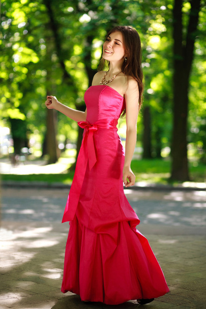 Mutlu genç kadın bir lüks uzun elbise yaz parkta - Fotoğraf, Görsel
