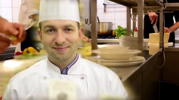 kuchař se usměje na kameramana v kuchyni-restaurace - Záběry, video