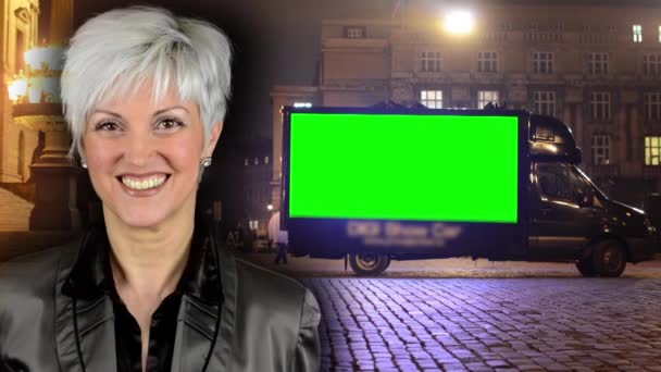 biznes w średnim wieku kobieta uśmiechy-reklama samochód-zielony ekran-nocne miejskie ulice-lampy (światła) - Materiał filmowy, wideo