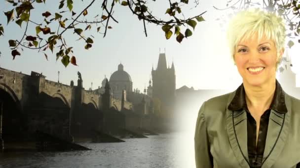 biznes w średnim wieku kobieta uśmiechy-Most Karola z drzewem (oddział)-wschód słońca-Praga, Czechy-rzeka - Materiał filmowy, wideo
