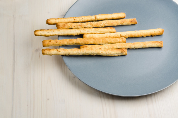 palitos de pan rústicos en un plato en la mesa de madera, primer plano, fondo
 - Foto, Imagen