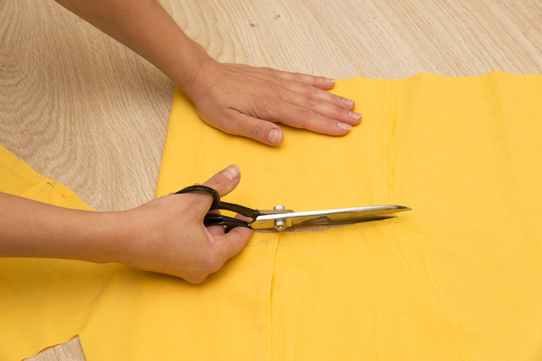 She cuts the fabric - Foto, afbeelding