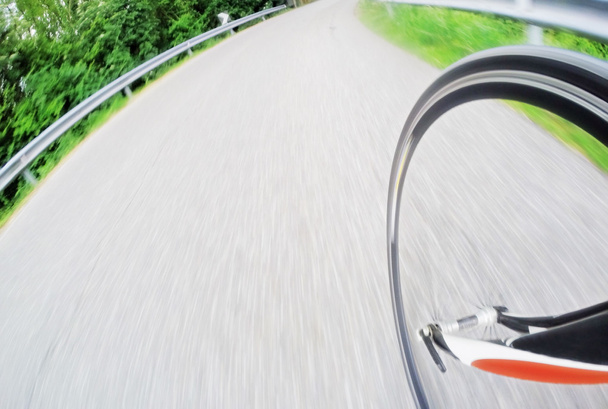 Detalhe da bicicleta de estrada da roda dianteira enquanto a bicicleta desce
 - Foto, Imagem