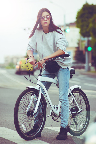 Colorful outdoor portrait of young pretty fashion model with bike. sexy woman posing in summer - Fotó, kép