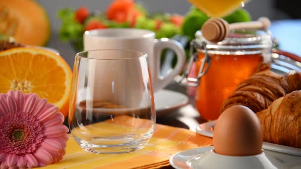 Verre de remplissage avec jus d'orange sur la table avec petit déjeuner
 - Séquence, vidéo