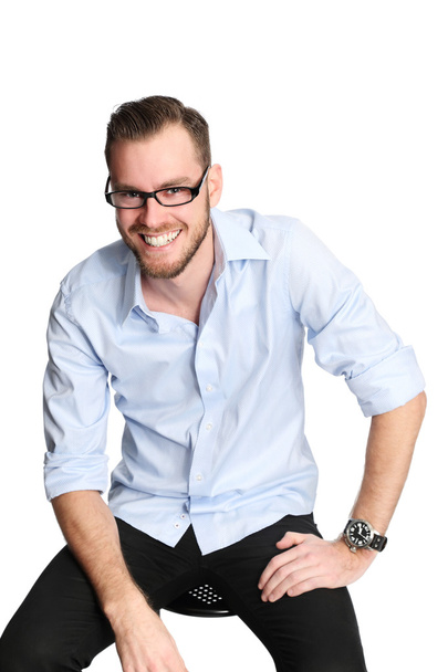 Smiling man sitting down in glasses - Φωτογραφία, εικόνα