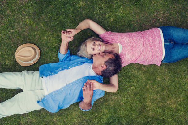 couple âgé couché sur une herbe et étreignant
 - Photo, image