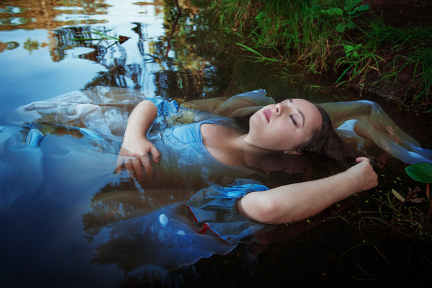 Молодая красивая утонувшая женщина лежит в воде
 - Фото, изображение