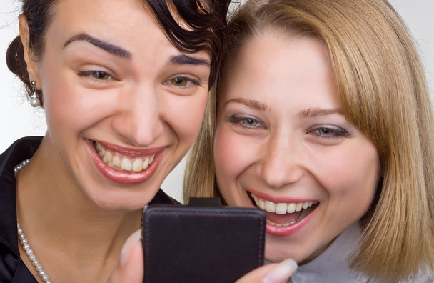 Dos mujeres riendo de cerca miran el teléfono móvil
 - Foto, Imagen