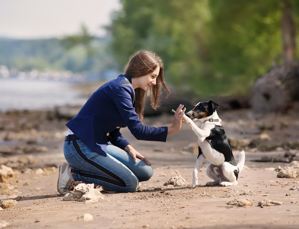 Young woman with her dog on the beach - Foto, immagini