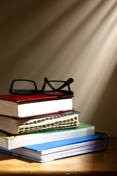 Kitap yığını ve bir çift gözlük - Fotoğraf, Görsel
