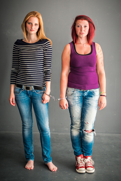 zwei wütende Frauen durch ein Paar Handschellen verbunden - Foto, Bild