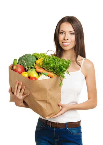 Lachende jonge vrouw die grocery shopping tas met gezond ve - Foto, afbeelding