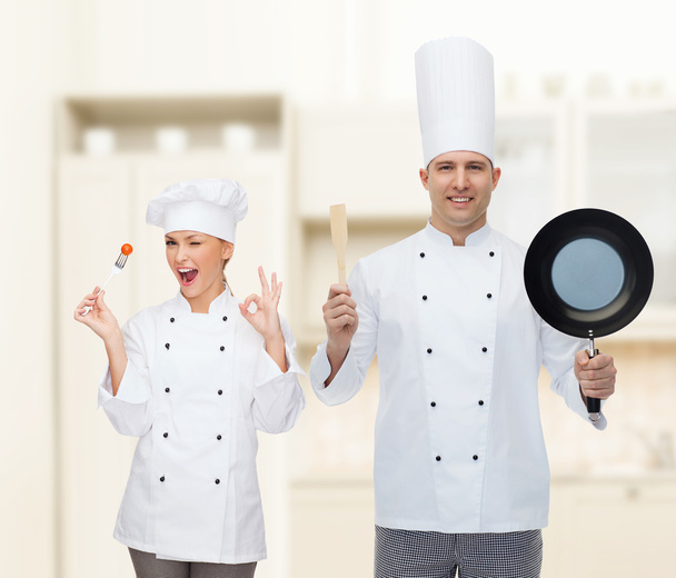 щасливий чоловічий шеф-кухар тримає сковороду і шпатель
 - Фото, зображення
