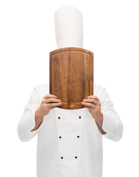 male chef cook covering face with cutting board - Valokuva, kuva