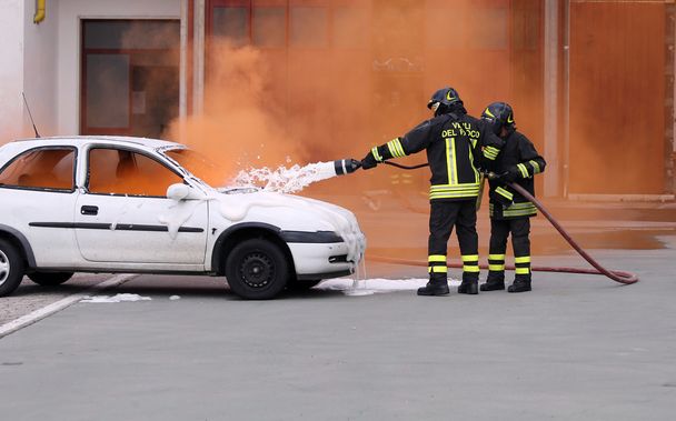 bomberos durante el ejercicio para apagar un incendio en un coche
 - Foto, imagen