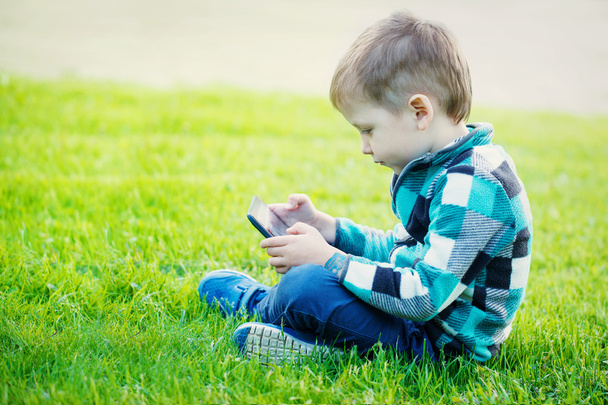 little boy with tablet sit on the grass - Foto, Imagen