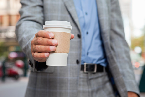 Businessman holding disposable cup - Fotoğraf, Görsel