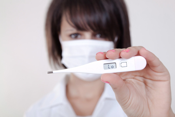 Female doctor holding medical thermometer - 写真・画像