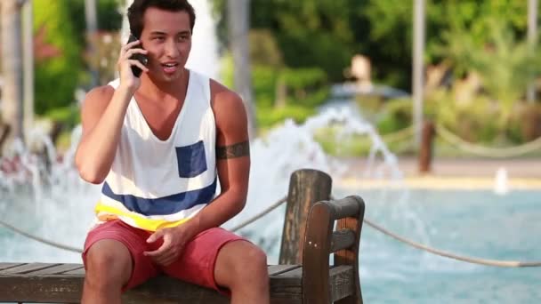 attraktive junge hübsche Junge spricht Smartphone - Filmmaterial, Video