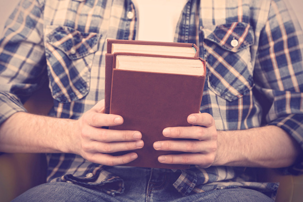 Young man holding books, close-up - Foto, imagen