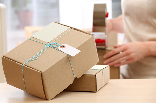 Woman packs parcel in post office - 写真・画像