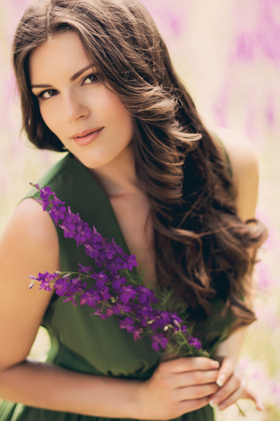 Woman with violet flowers - Фото, изображение