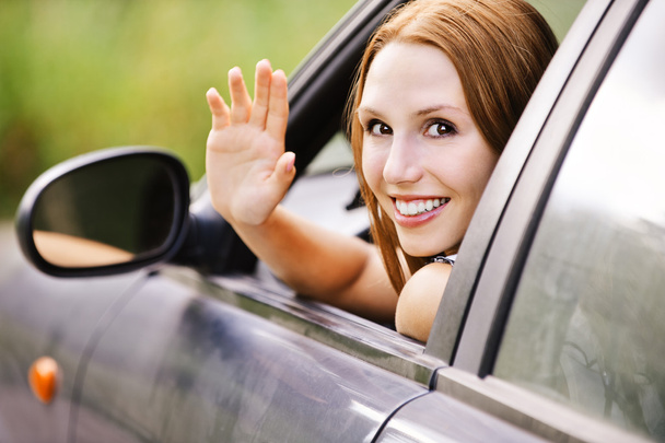 hübsche junge Frau sitzt im Auto und schaut aus dem Fenster - Foto, Bild