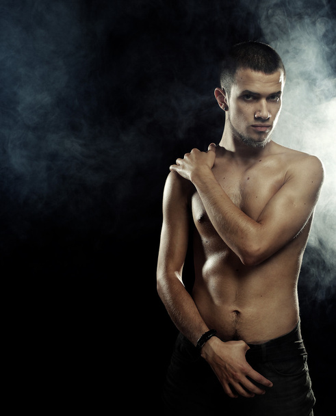  a muscular male model against dark  background - Fotoğraf, Görsel