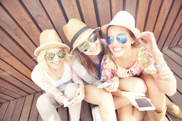 Amigos do sexo feminino usando smartphones
 - Foto, Imagem