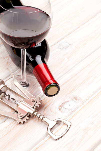 rode wijn fles, glas en kurkentrekker - Foto, afbeelding