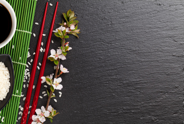 Japanse sushi eetstokjes, rijst en sakura - Foto, afbeelding
