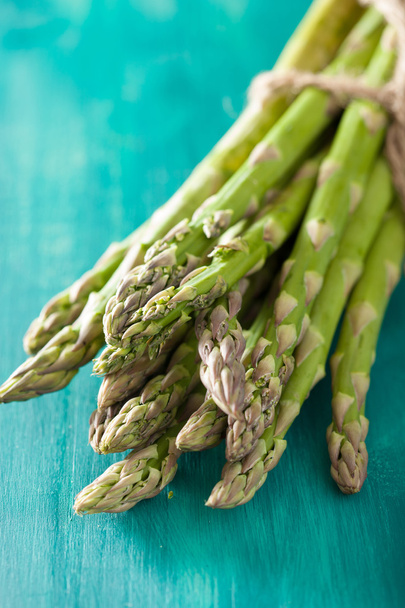 bunch of fresh asparagus on turquoise background - Foto, imagen