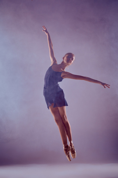 Beautiful young ballet dancer jumping on a lilac background.  - Foto, Bild