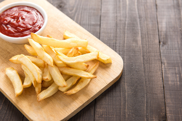 French fries with ketchup on wooden background. - Zdjęcie, obraz