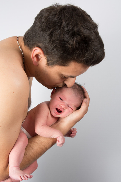 Liefdevolle vader knuffelen zijn pasgeboren baby - Foto, afbeelding
