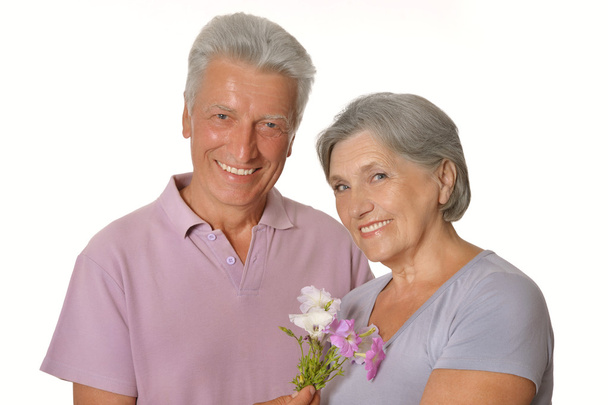 smiling old couple with flowers - Fotó, kép