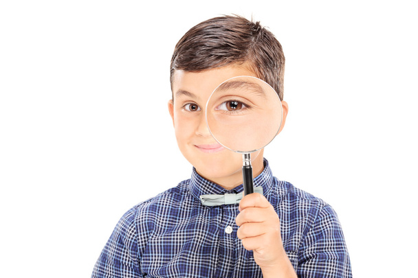 Boy looking through a magnifying glass  - Foto, immagini