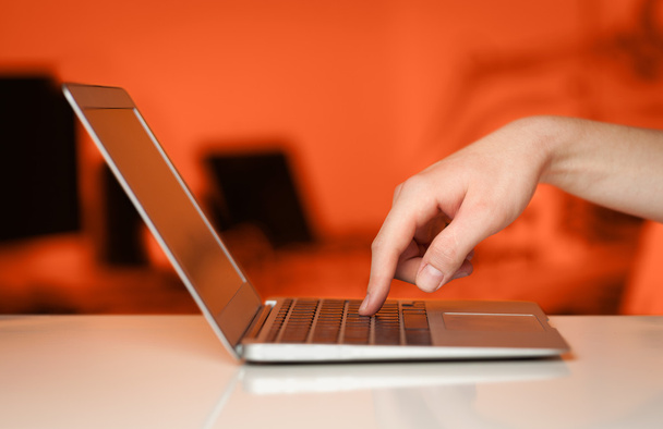 a gomb megnyomásával modern laptop számítógép színes háttérb üzletember - Fotó, kép