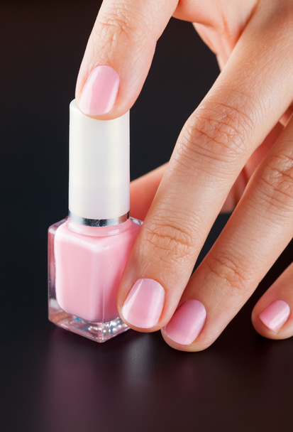 Pink bottle of nail polish in woman hand - Fotoğraf, Görsel