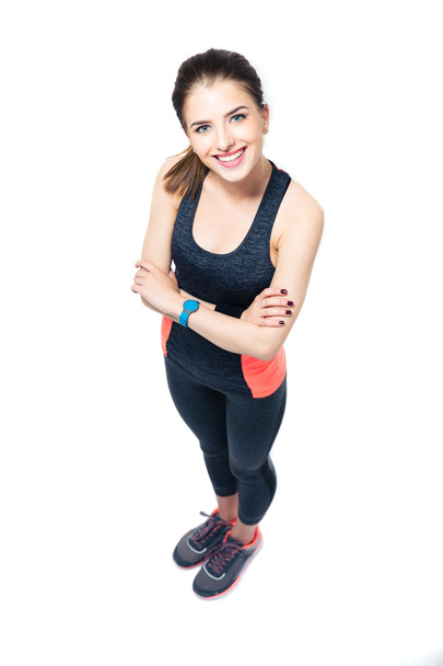 Happy sporty woman standing with arms folded - Foto, imagen