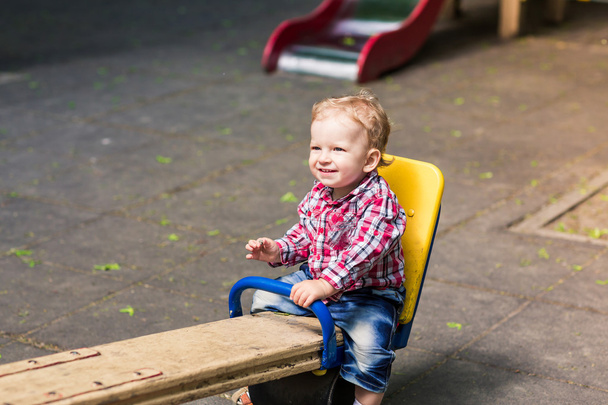 Cute baby boy on a seesaw swing  - Zdjęcie, obraz